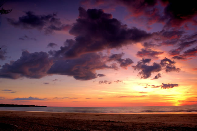 Dramatic cloudscape accentuates the setting sun. Casuarina Beach, Darwin, Northern Territory, Australia.