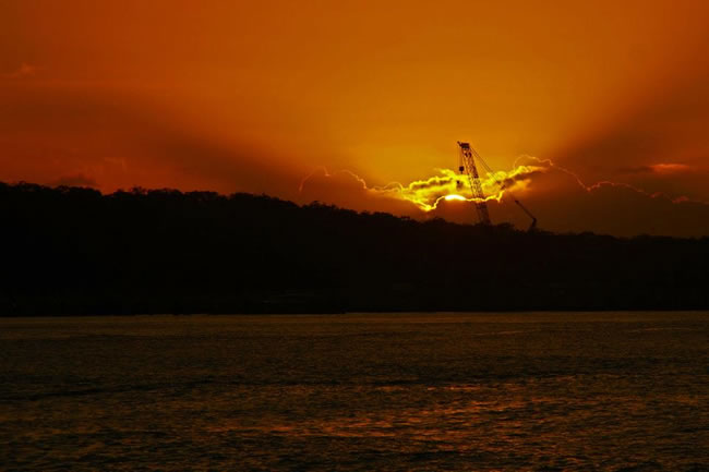 WOW! Spectacular sunrise lights up a construction crane. Gladstone Harbour, Queensland, Australia.