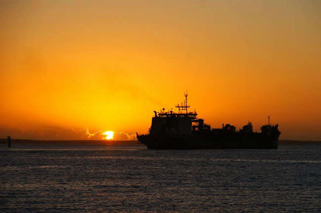 The dredge Rotterdam underway at dawn. Gladstone Harbour, Queensland, Australia.