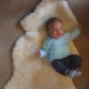 Baby on a sheepskin baby rug.